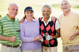 Photo of two couples posing with their golf clubs. Link to What to Give.